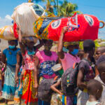 Women and children in Mozambique holding on to their goods