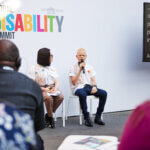We Can Work and OPD representative youth speak at GDS in a fireside chat about inclusive employment. There is a GDS logo in the background and two young people with albinism are on stage delivering a presentation.