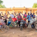 Members of Association Vivre de Nouveau and the IMPACT-BF project, including wheelchair users, raise their joined hands together in Ouagadougou, Burkina Faso.
